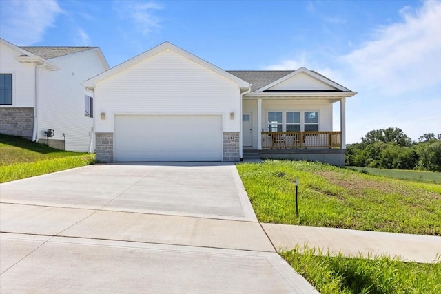 612 W Walnut Pl, Norwalk, IA 50211 - view of front of home featuring an attached garage, concrete driveway, covered porch, stone siding, and a front yard