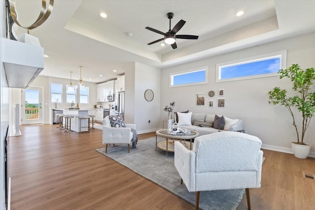 612 W Walnut Pl, Norwalk, IA 50211 - living room with a tray ceiling, plenty of natural light, wood finished floors, recessed lighting, and ceiling fan
