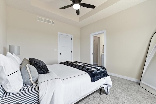 612 W Walnut Pl, Norwalk, IA 50211 - carpeted bedroom with a tray ceiling, ensuite bath, and a ceiling fan