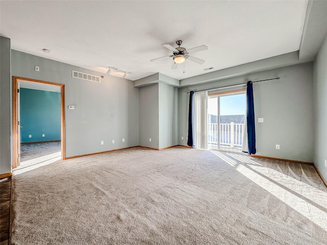 spare room featuring ceiling fan, carpet flooring, and rail lighting