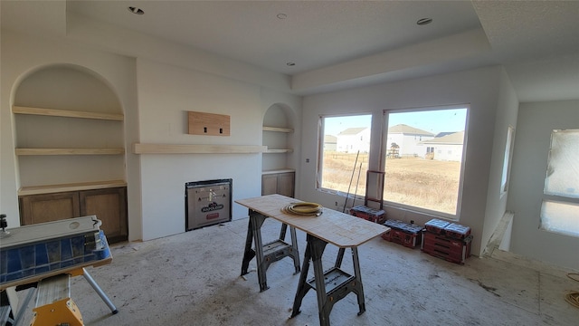 dining room with built in shelves and a raised ceiling