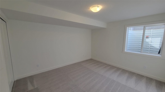 empty room with light colored carpet and baseboards