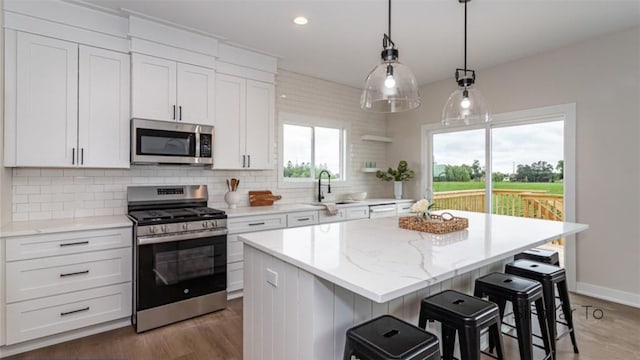 kitchen with white cabinetry, appliances with stainless steel finishes, and a center island