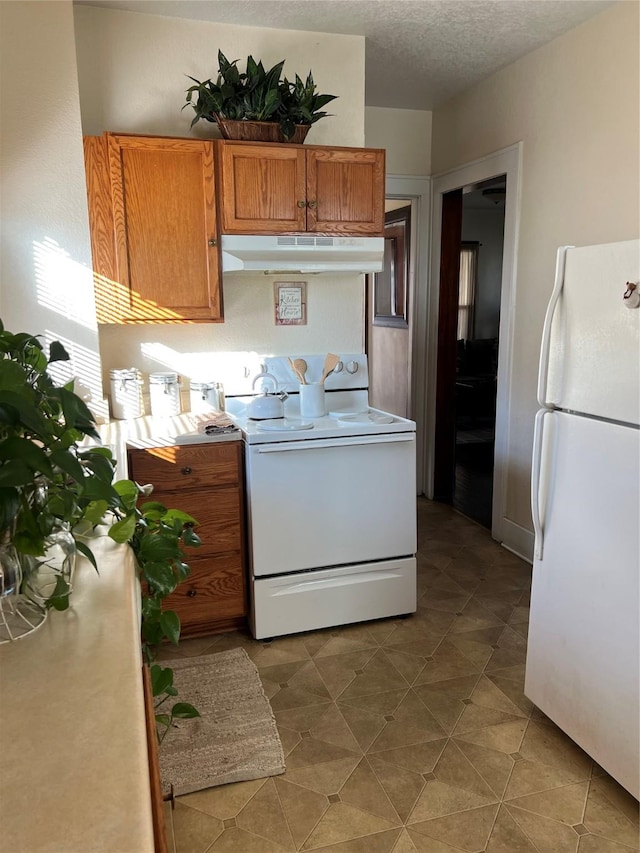 kitchen with white appliances and a textured ceiling