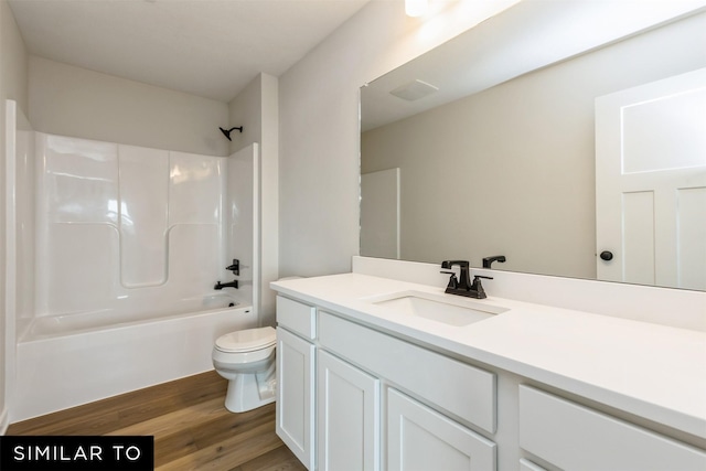 full bathroom featuring hardwood / wood-style flooring, shower / washtub combination, vanity, and toilet