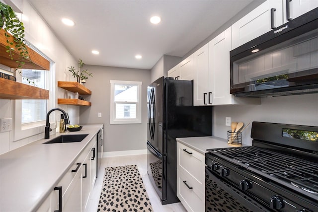 kitchen with sink, black appliances, and white cabinets