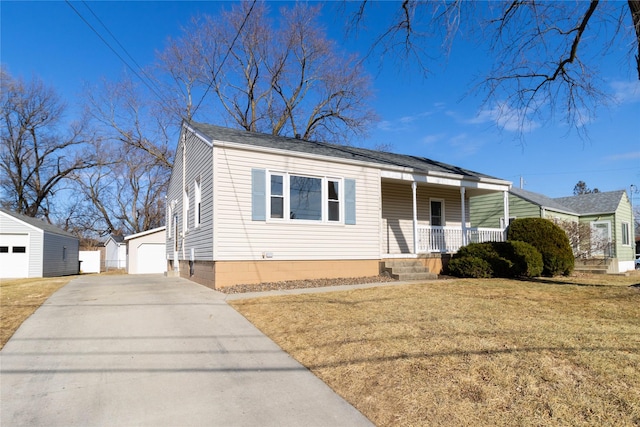 view of front of house with an outbuilding, a garage, a front lawn, and a porch