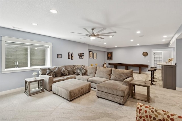 carpeted living room with ceiling fan