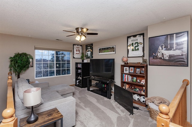 living room featuring ceiling fan, a textured ceiling, and carpet flooring