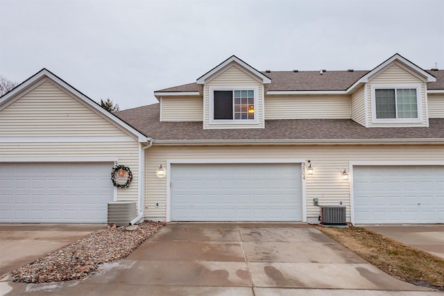 view of front of property featuring a garage and central AC