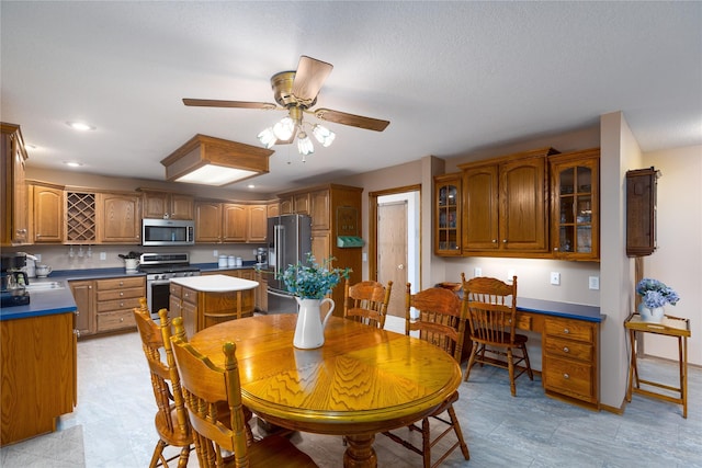 dining area with built in desk, recessed lighting, baseboards, and ceiling fan