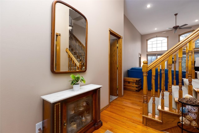 interior space featuring recessed lighting, arched walkways, light wood-style floors, and stairs