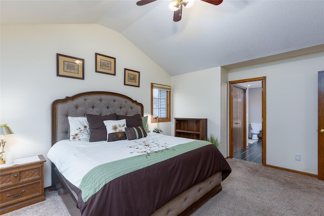 carpeted bedroom featuring ceiling fan, baseboards, ensuite bathroom, and lofted ceiling