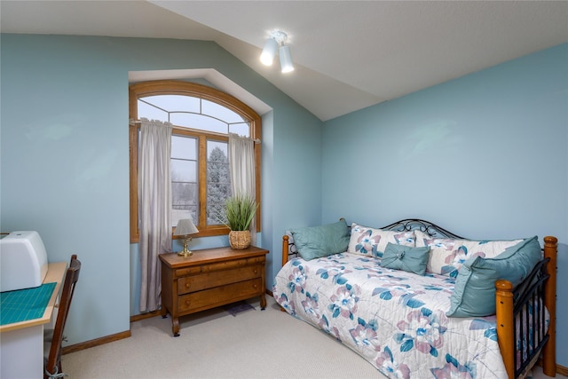 bedroom with vaulted ceiling, carpet flooring, and baseboards