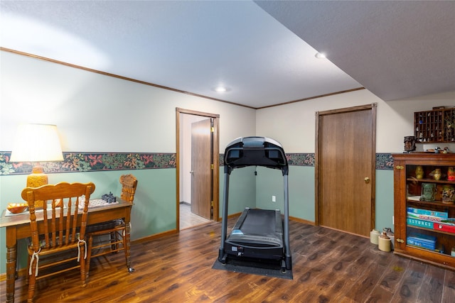 exercise area featuring crown molding, wood finished floors, and baseboards