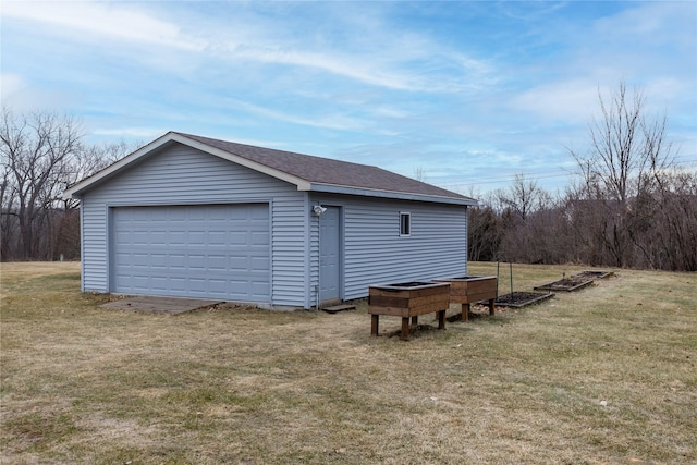 detached garage featuring a vegetable garden