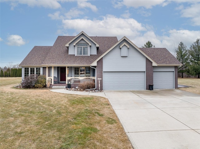 traditional home featuring driveway, an attached garage, covered porch, a front lawn, and brick siding