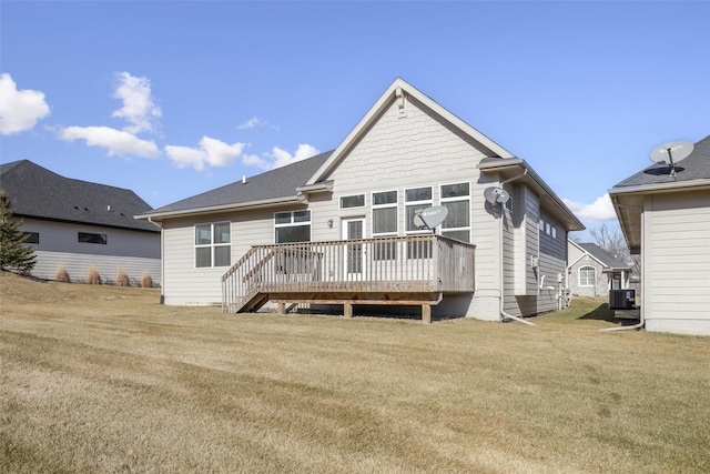 back of property with a deck, central air condition unit, and a lawn