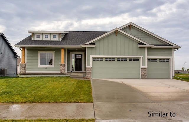 craftsman inspired home with a garage, central AC unit, and a front yard