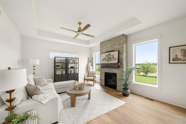 1083 NW 35th St, Grimes, IA 50111 - living area featuring a tray ceiling, ceiling fan, plenty of natural light, and wood finished floors