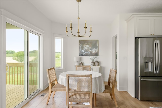 1083 NW 35th St, Grimes, IA 50111 - dining room with a chandelier, light wood-style flooring, and baseboards