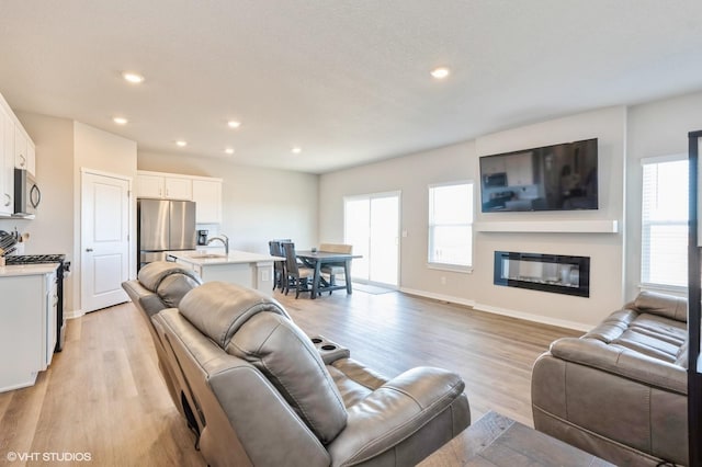 living room featuring sink and light hardwood / wood-style floors