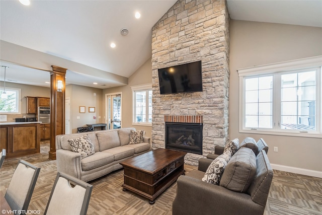 living room featuring a fireplace, high vaulted ceiling, and a healthy amount of sunlight