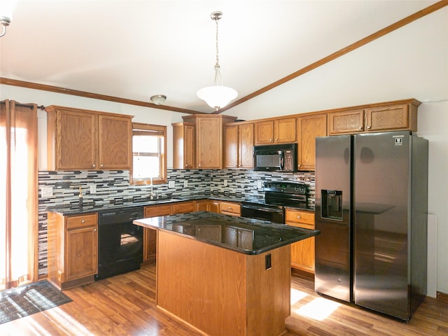 kitchen featuring lofted ceiling, hanging light fixtures, a center island, tasteful backsplash, and black appliances