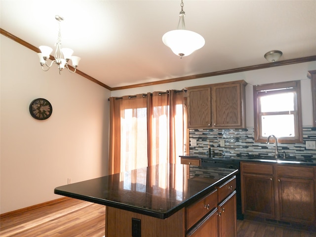 kitchen featuring pendant lighting, backsplash, ornamental molding, and a center island