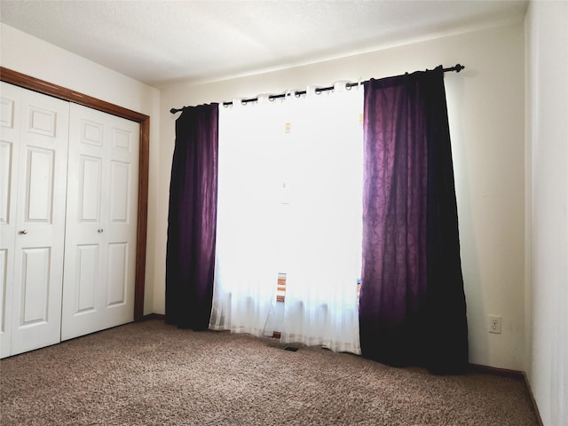 unfurnished bedroom with carpet flooring and a closet