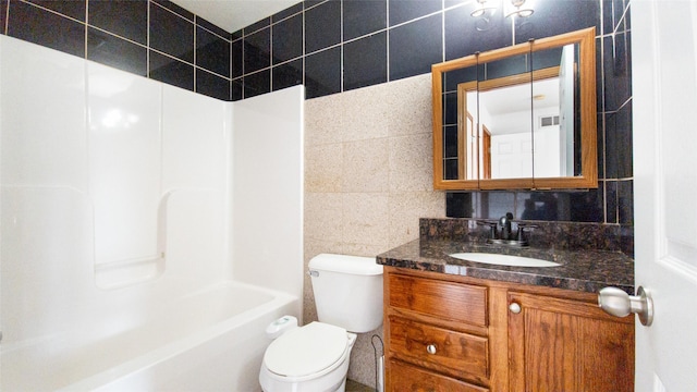 full bathroom with tile walls, vanity, bathing tub / shower combination, and toilet