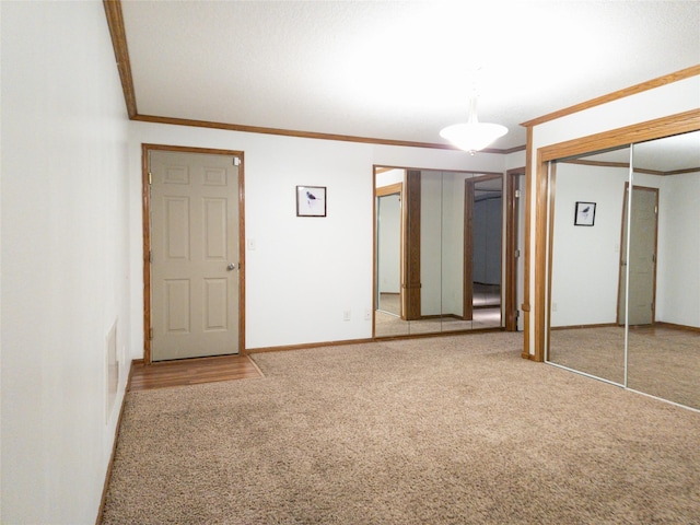 unfurnished bedroom with ornamental molding and carpet