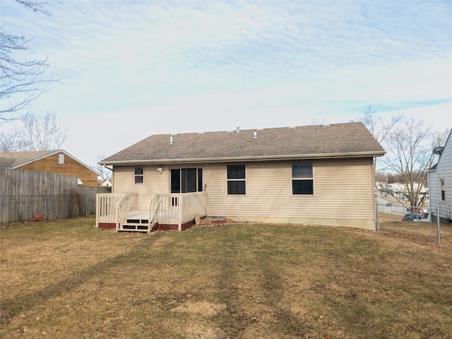 back of property with a wooden deck and a yard