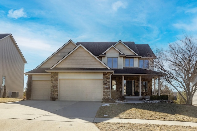 craftsman-style house featuring cooling unit, a garage, and covered porch