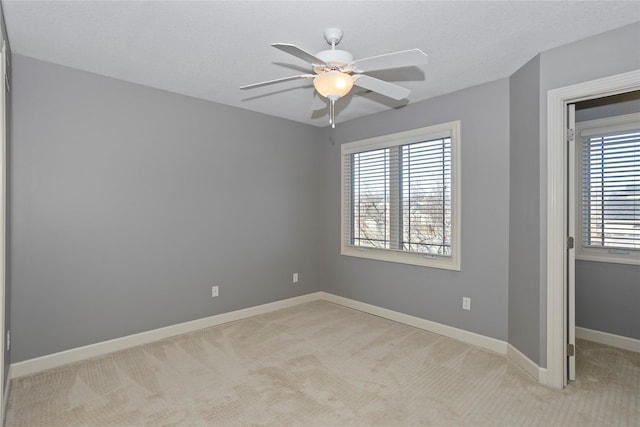 empty room featuring light carpet, a textured ceiling, and ceiling fan