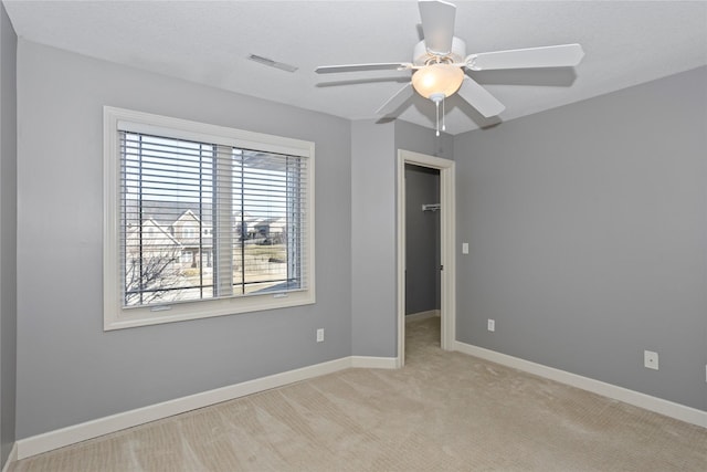 carpeted spare room with ceiling fan