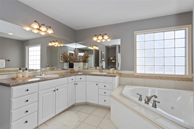 bathroom featuring tile patterned flooring, vanity, and tiled tub