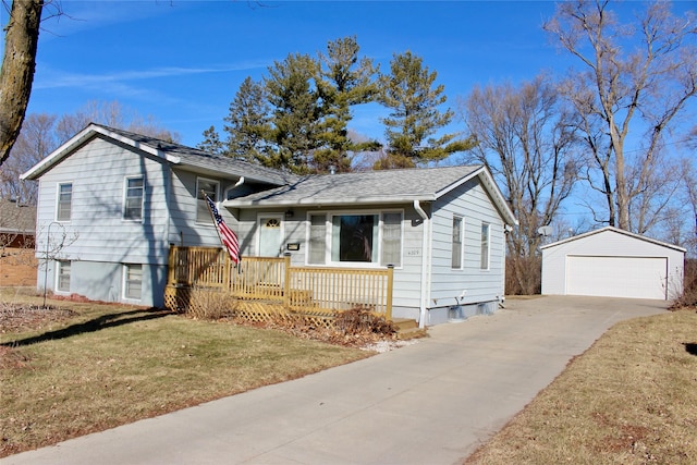 split level home featuring covered porch, a front lawn, an outdoor structure, and a detached garage