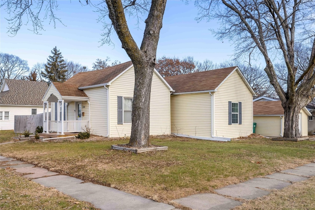 view of side of home featuring a porch and a lawn