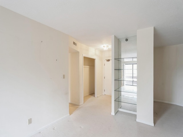 carpeted spare room featuring a textured ceiling