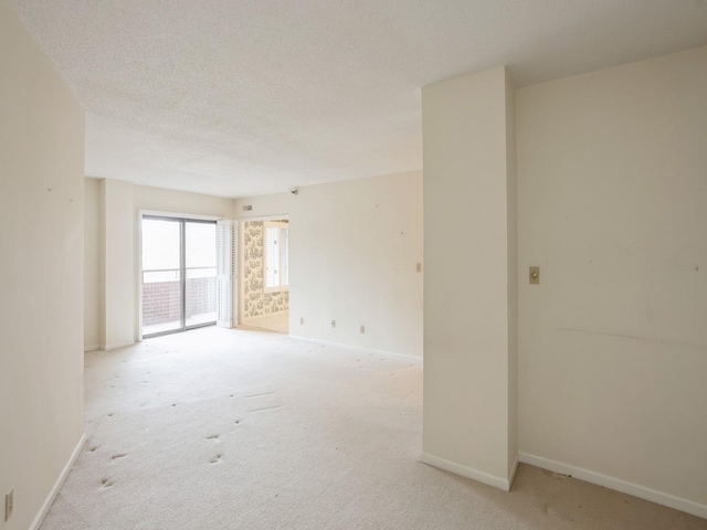 carpeted spare room featuring a textured ceiling