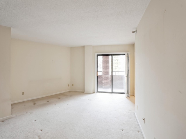 unfurnished room with light colored carpet and a textured ceiling