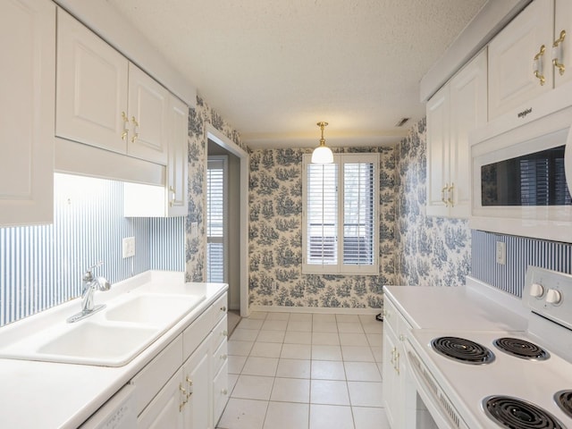 kitchen featuring sink, white cabinets, white appliances, and decorative light fixtures