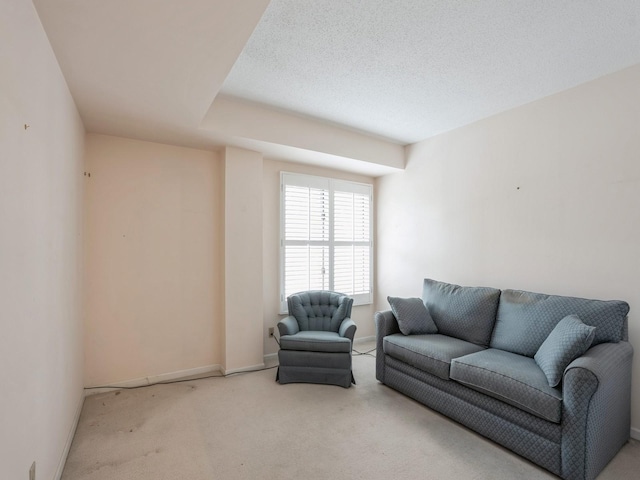 living room featuring light colored carpet and a textured ceiling