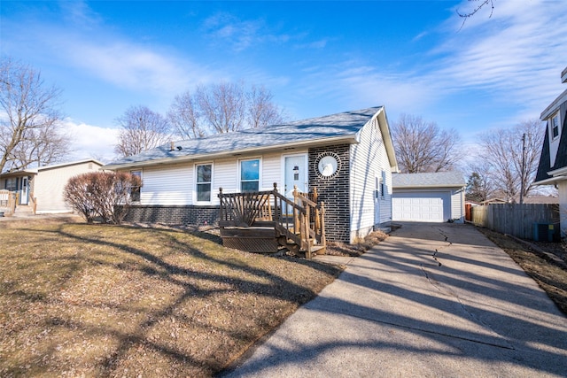 ranch-style home featuring an outbuilding, brick siding, central air condition unit, fence, and a front lawn