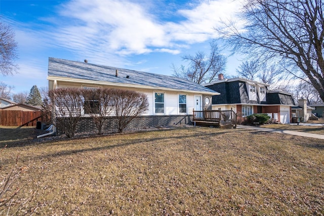 back of property featuring a deck, a yard, brick siding, and fence