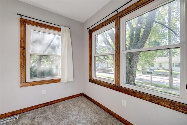 unfurnished room with plenty of natural light and carpet