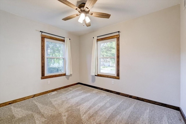 carpeted spare room featuring ceiling fan