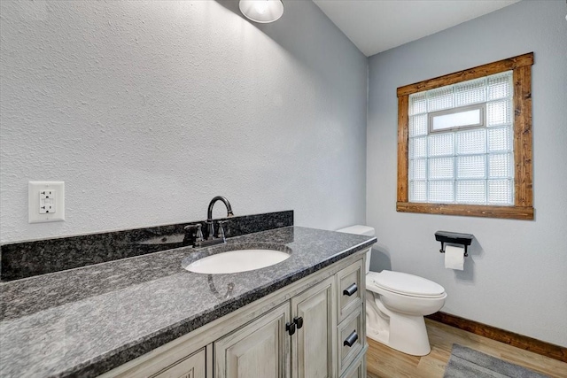 bathroom with hardwood / wood-style flooring, vanity, and toilet