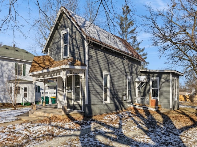 snow covered property with covered porch